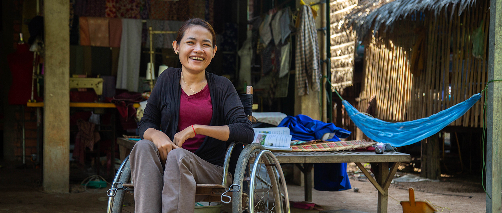 A woman in a wheelchair smiles at the camera in Cambodia (WaterAid)